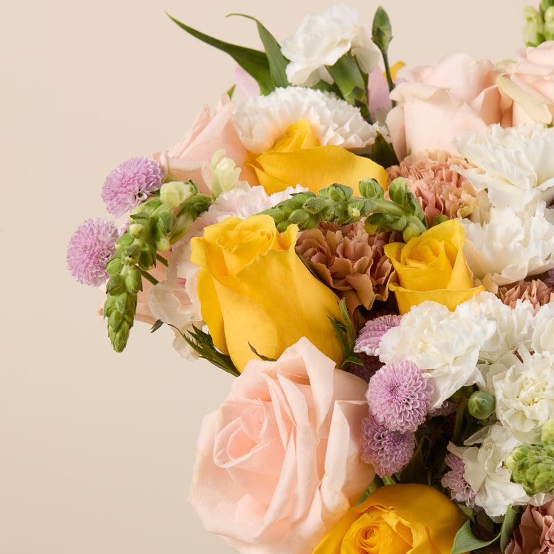 Peach and cream rose bouquet with carnations, alstroemeria, and snapdragons.
