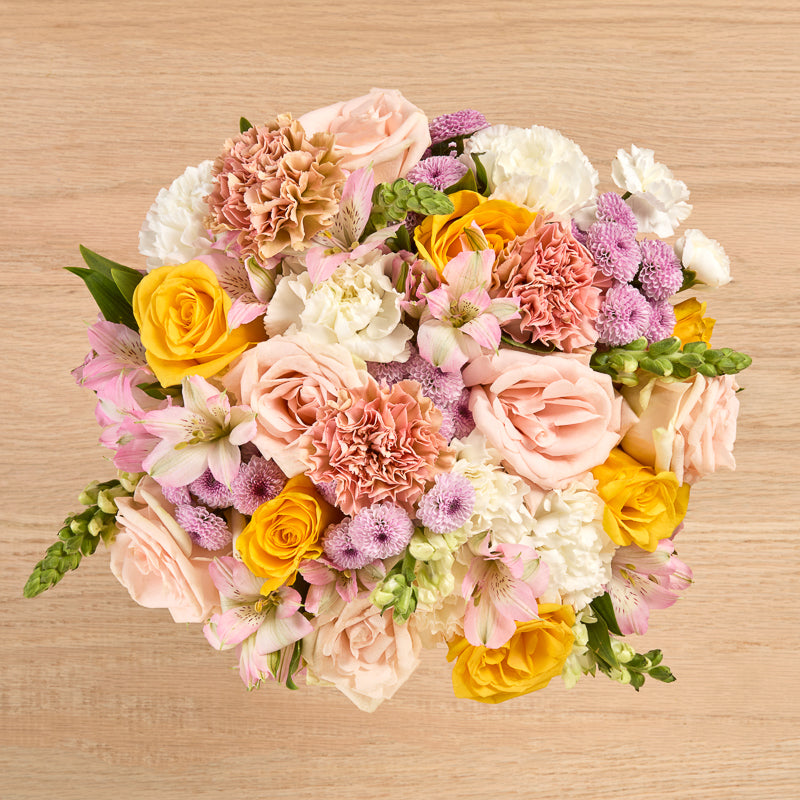 Peach and cream rose bouquet with carnations, alstroemeria, and snapdragons.